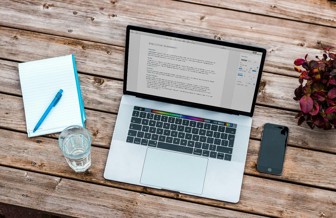 Laptop,mobile,glass and notebook on a desk